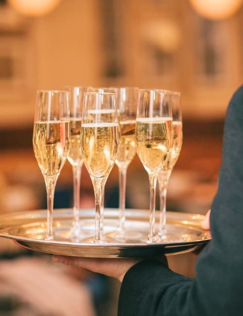 A tray of champagne flutes carried at a hospitality event